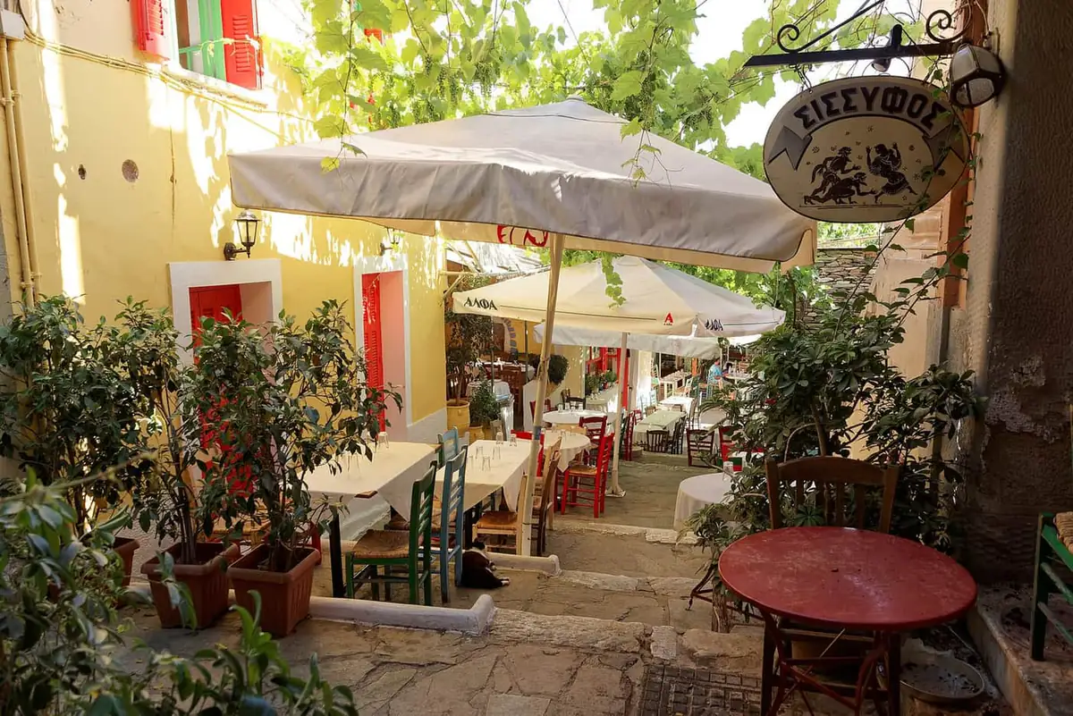 Taverna tables on Mnisikleous Street in the Plaka district, with chairs set along the steps