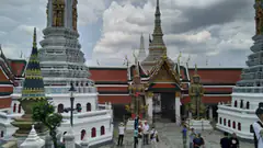 The Grand Palace complex in Bangkok, with gilded chedis and mythological guardian statues