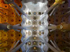 Looking up at the tree-like columns and colorful vaulted ceiling inside the Sagrada Familia