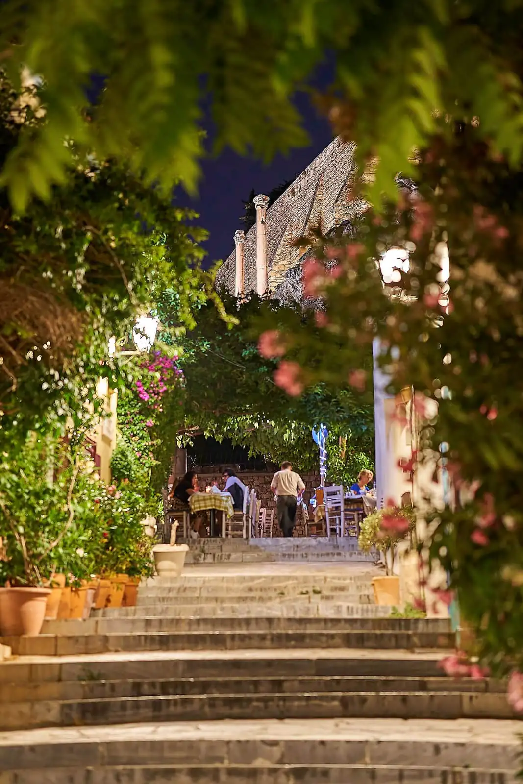 Taverna tables on a stepped lane in Plaka, Athens, at night