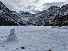 Snow-covered valley in the High Atlas mountains with a small snowman in the foreground