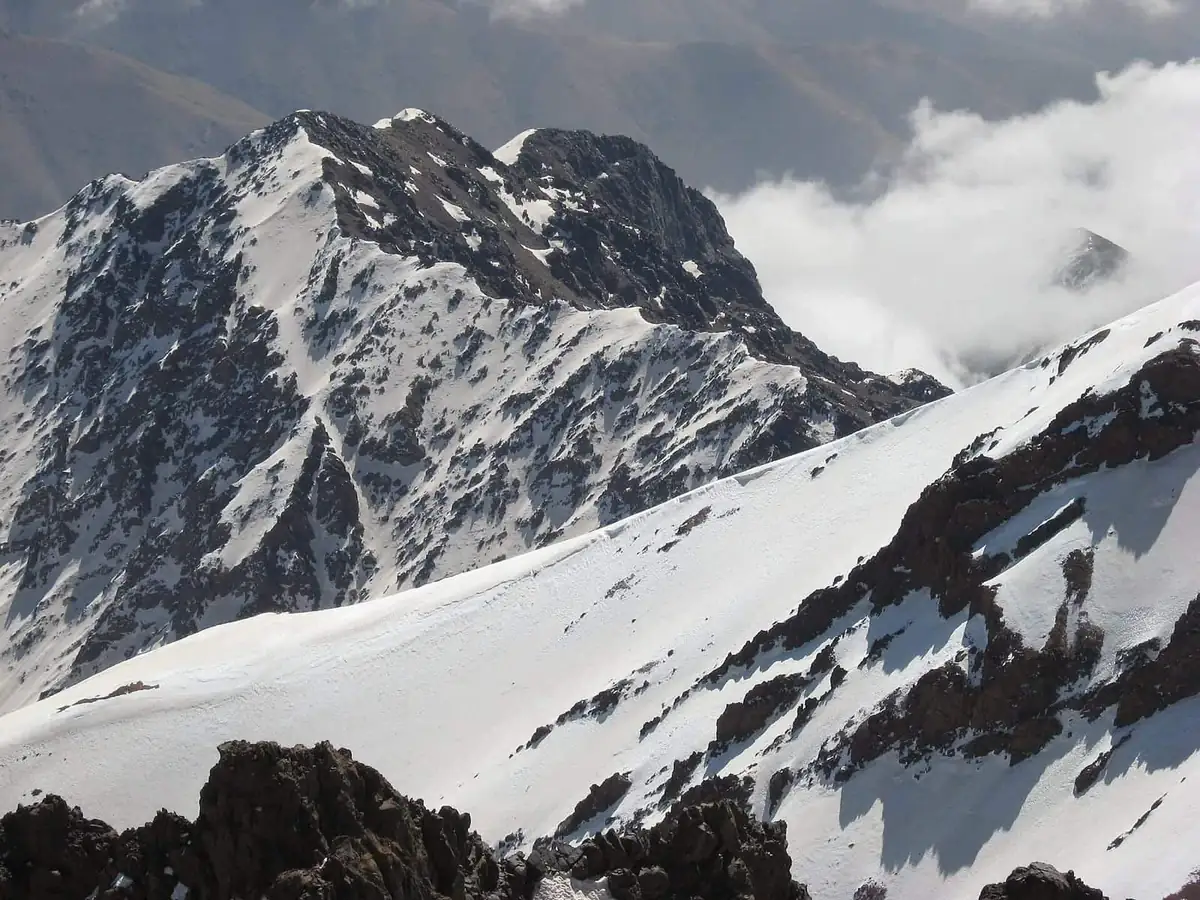 Snow-covered ridges in the Atlas mountains with cloud banked below the peaks