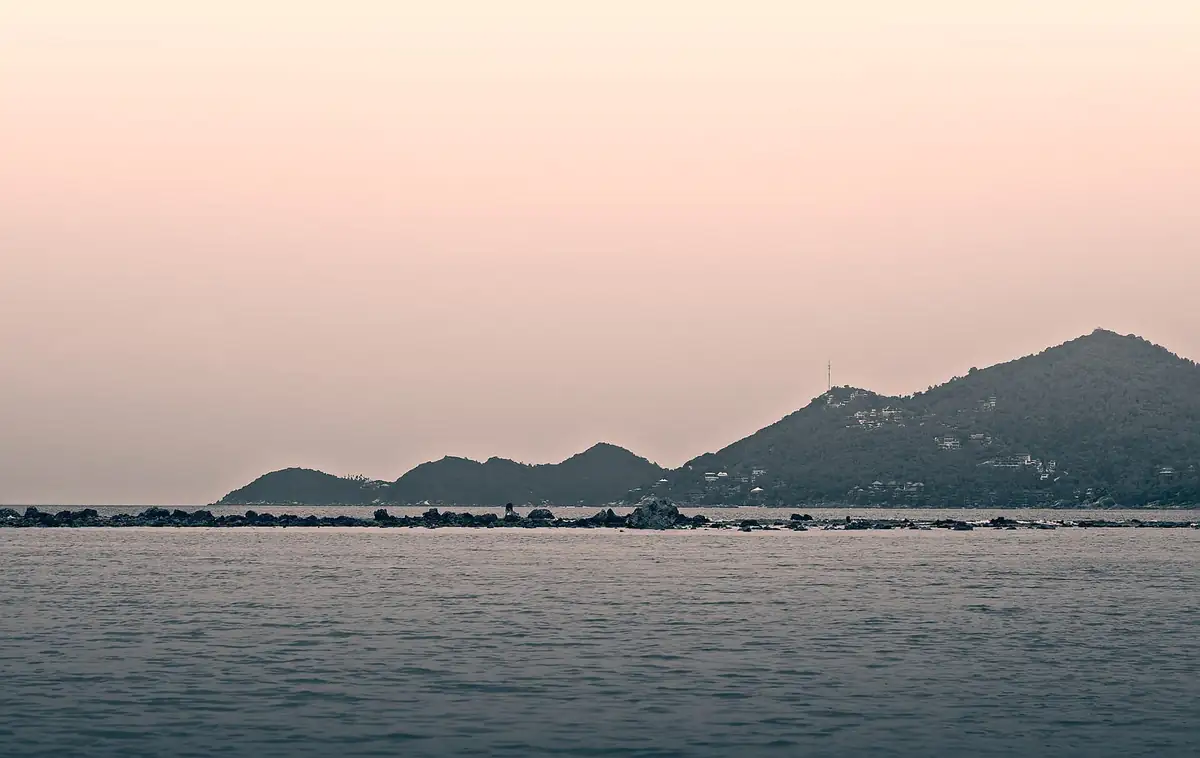 Calm sea and forested headlands off the Koh Samui coast at dusk
