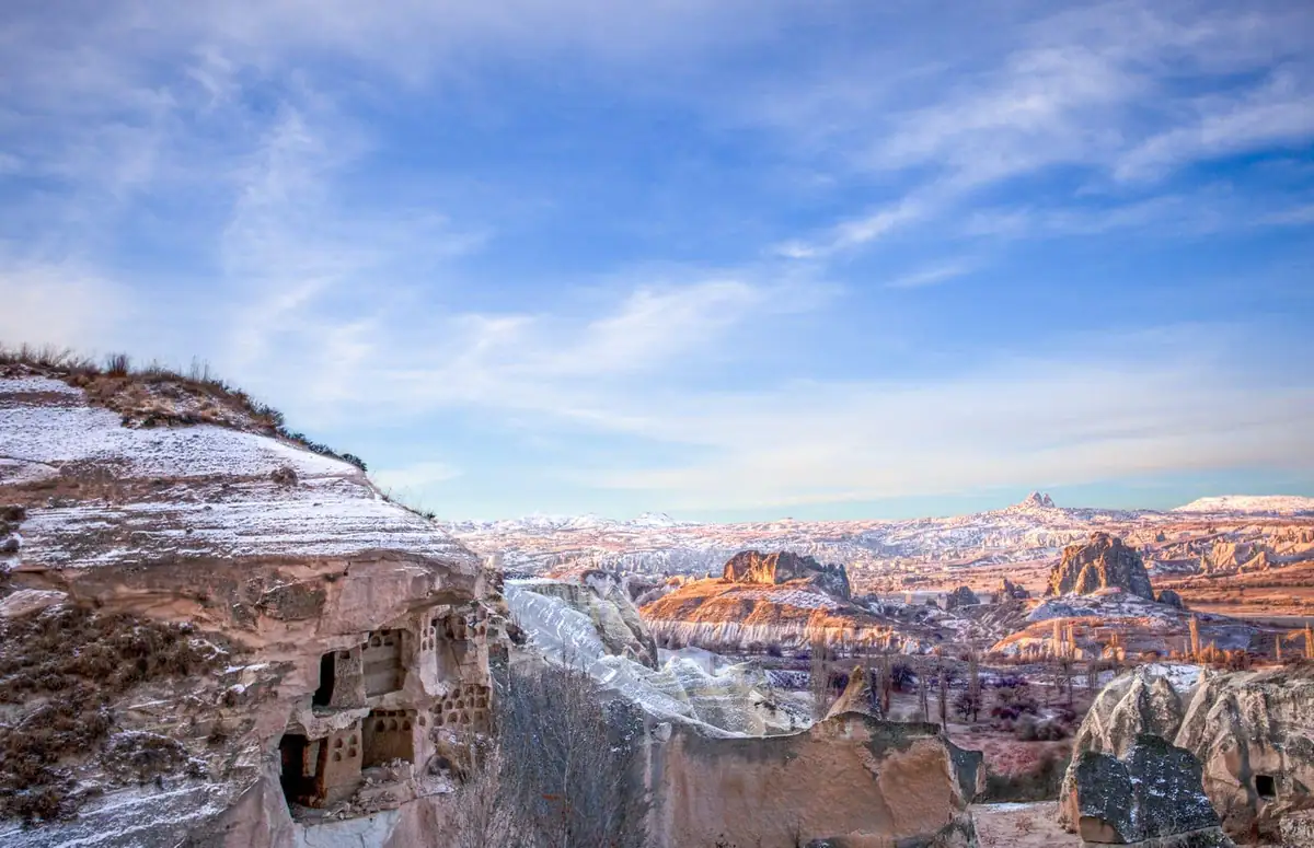 Snow-dusted fairy chimneys and cave dwellings across the valleys of Cappadocia on a clear winter morning