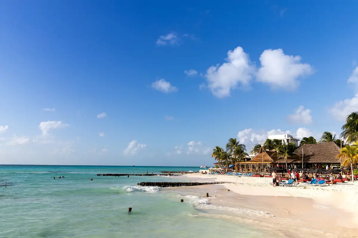 Swimmers and palapas on a calm Isla Mujeres beach