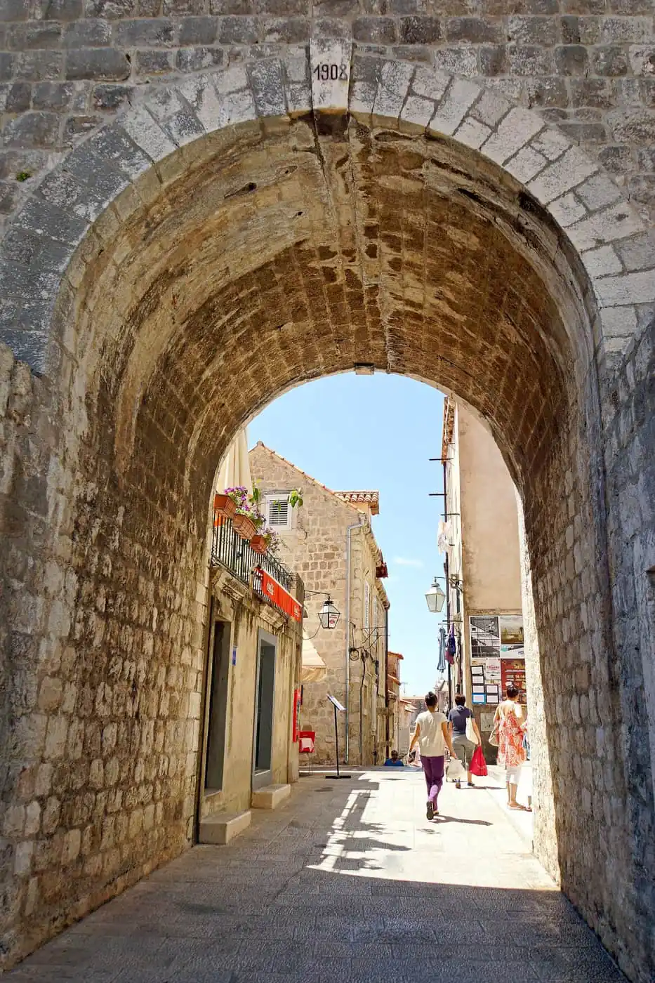 Walkers under the stone arch on the walls