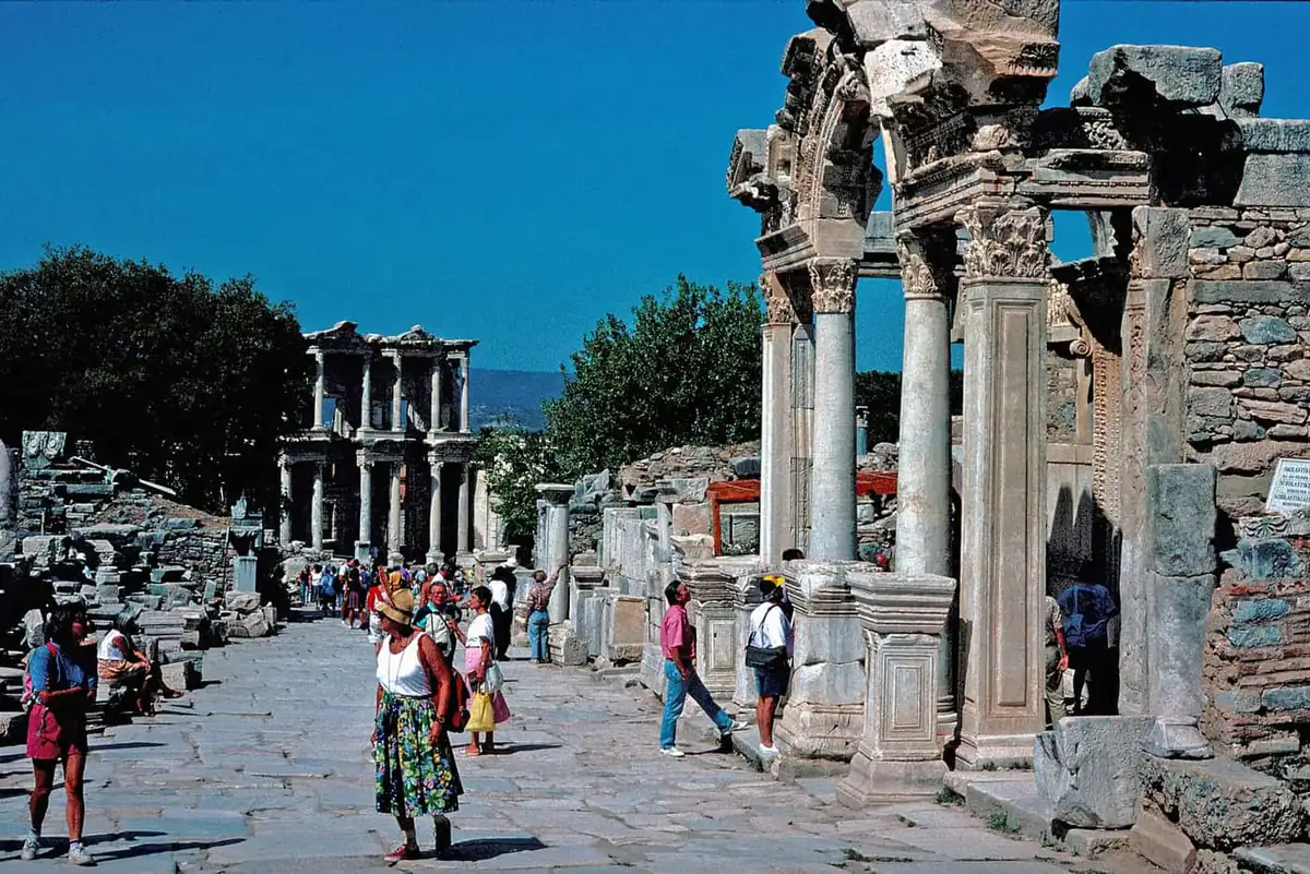 Visitors on Curetes Street beside the ornate Temple of Hadrian