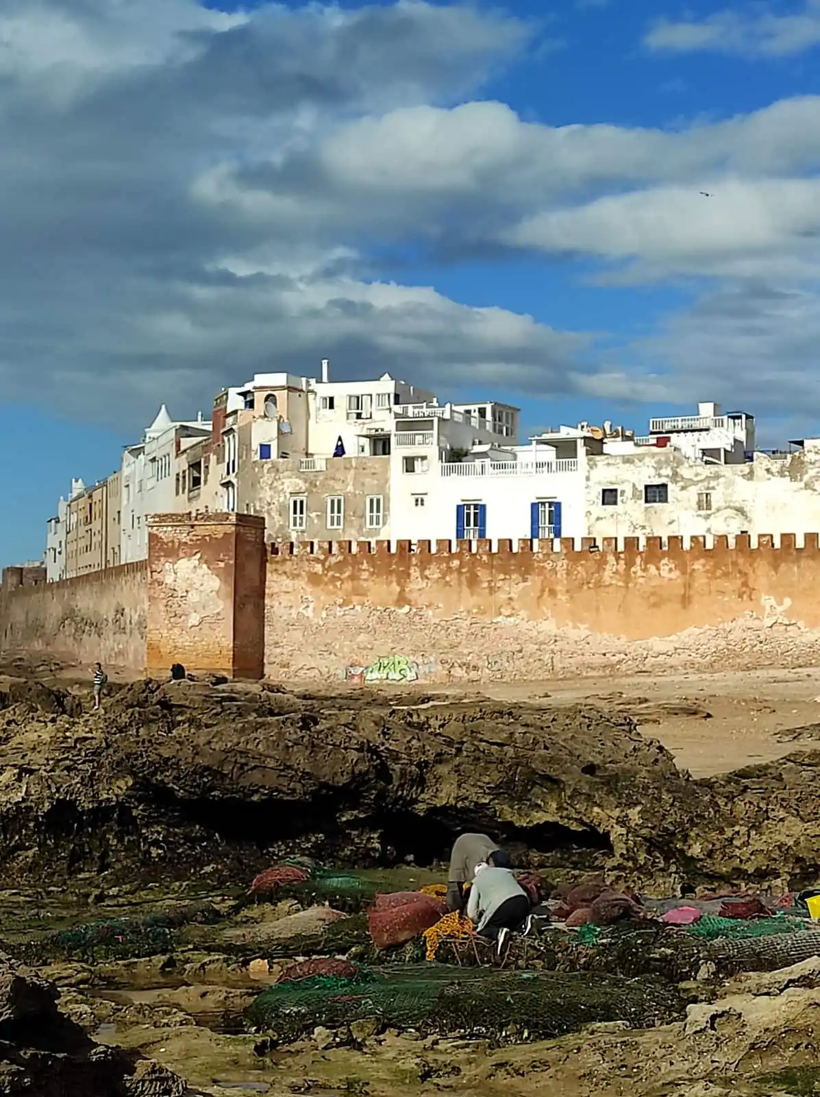 Essaouira's sea walls seen from the rocks, with fishing nets drying in front