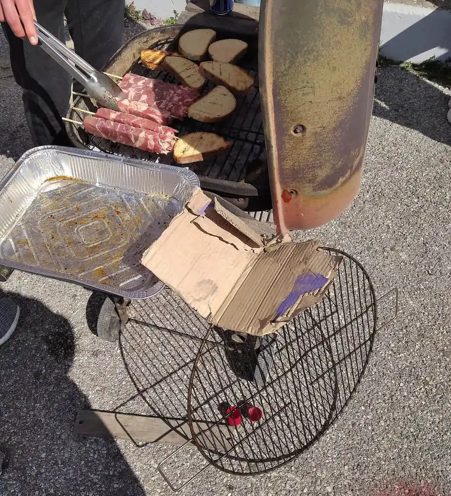 Raw pork souvlaki skewers and bread grilling over charcoal outdoors