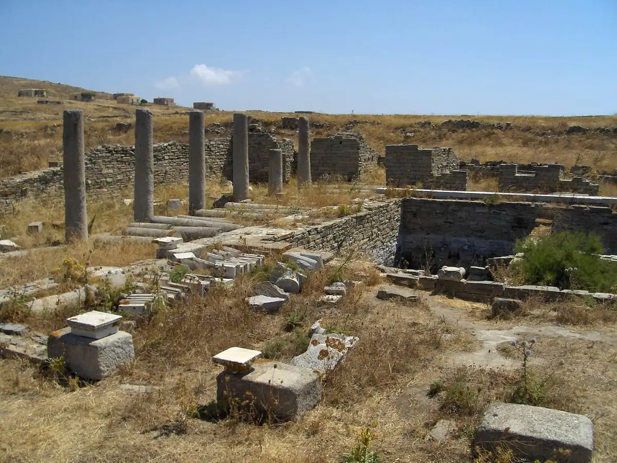 Stone columns and ruined walls of ancient Delos under a clear sky