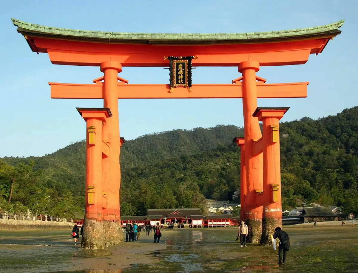 The great vermilion torii of Itsukushima Shrine at low tide with the shrine buildings behind