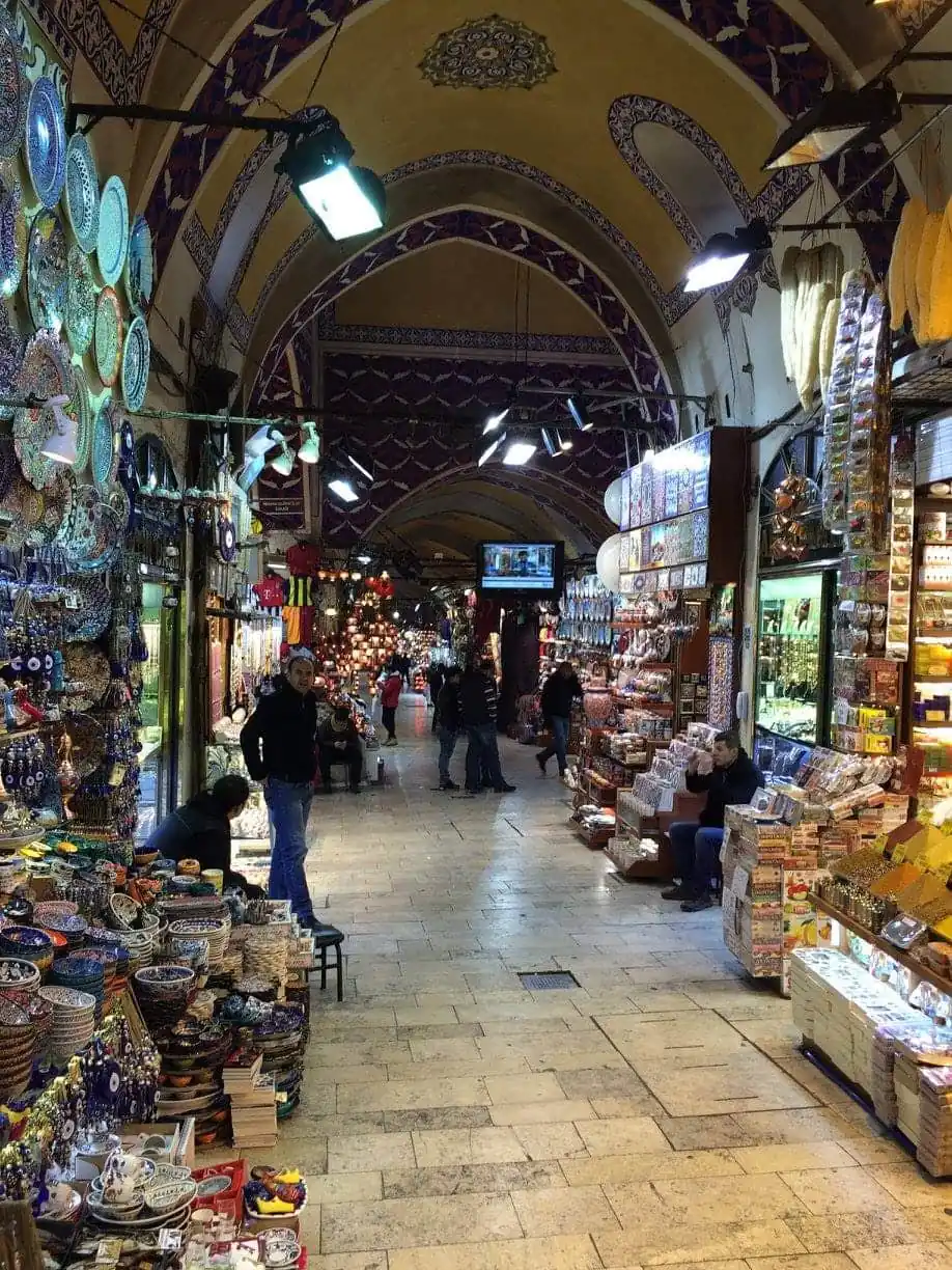 Stalls of ceramics, lamps and sweets lining a vaulted arcade in the Grand Bazaar