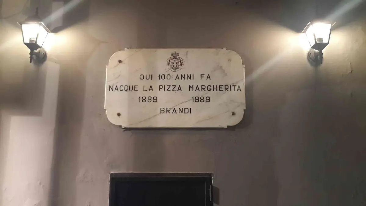 Marble plaque in Naples marking a century of pizza Margherita, 1889 to 1989, lit up at night
