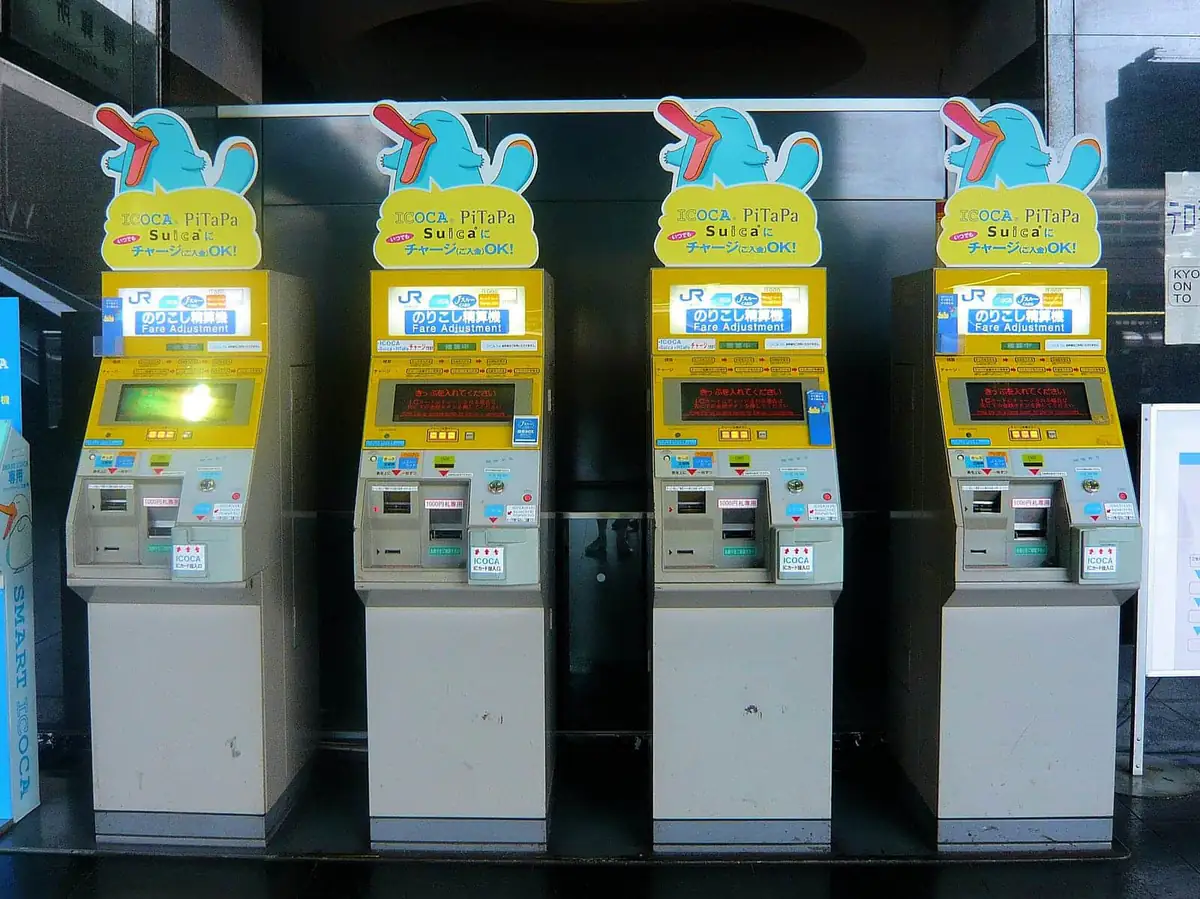 IC card charge and fare adjustment machines lined up inside a JR station in Kyoto