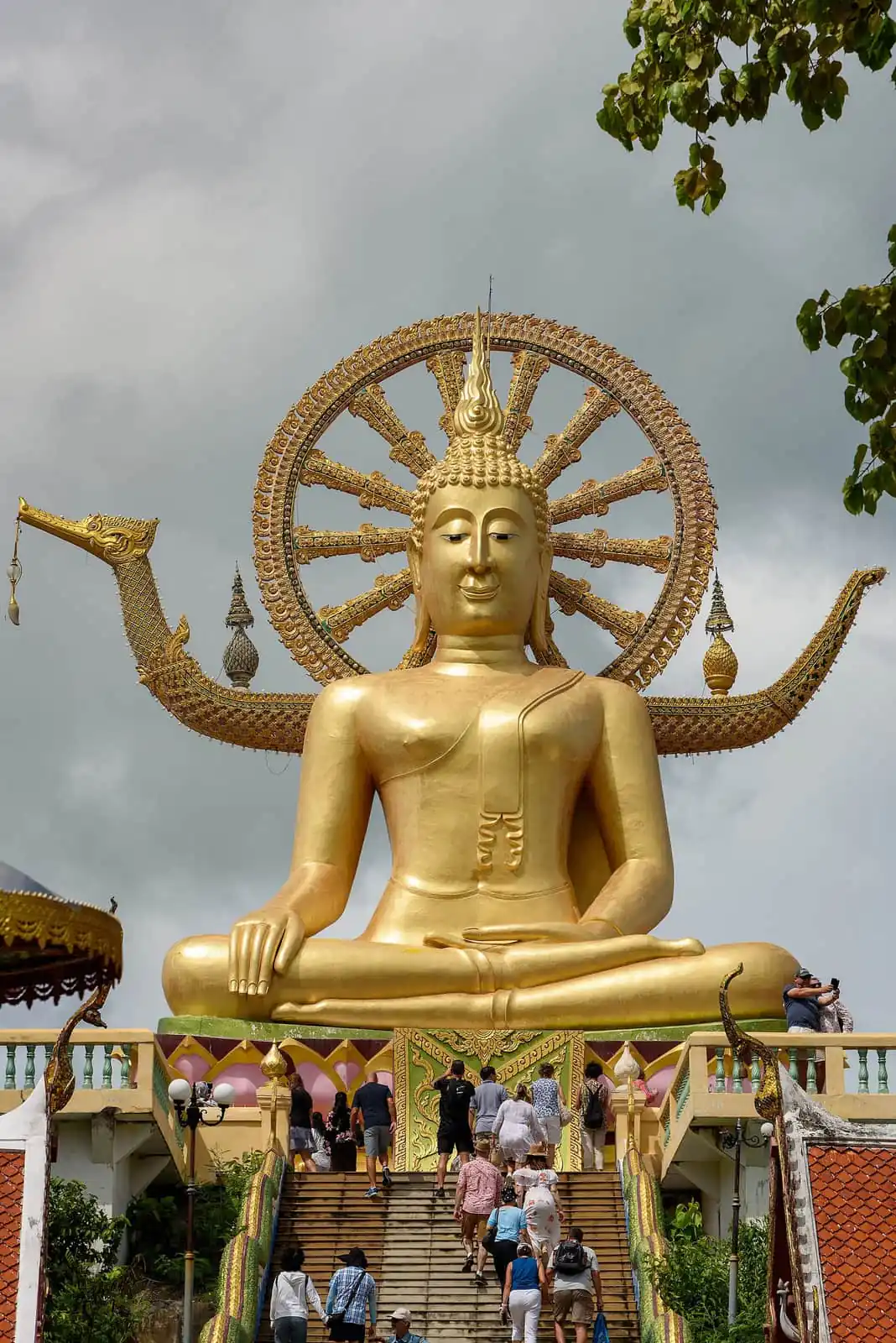The 12-metre gold Big Buddha statue at Wat Phra Yai on Koh Samui with visitors climbing the stairs