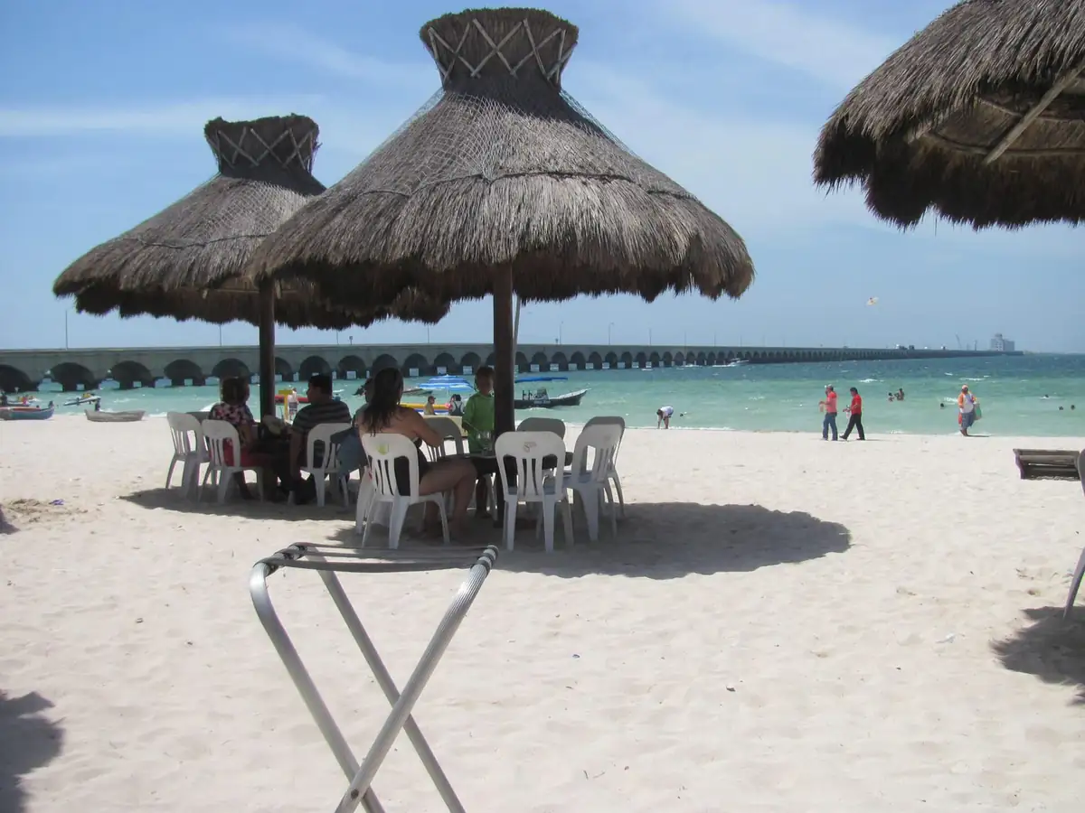 Thatched palapas and swimmers on the beach at Progreso