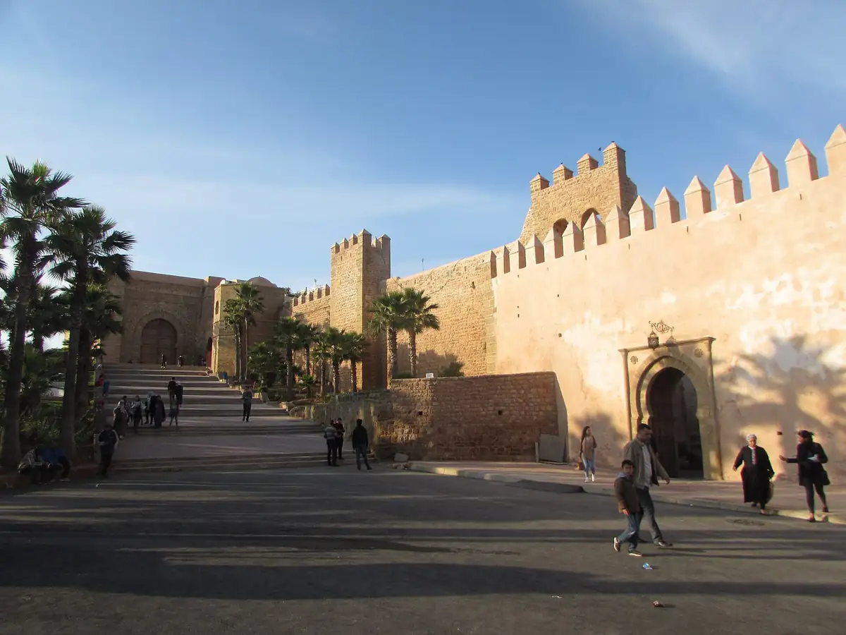 Crenellated stone walls and the Almohad gate of the Kasbah of the Udayas lit by late-afternoon sun