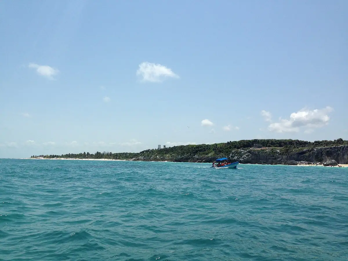 A tour boat below the cliffs near Tulum