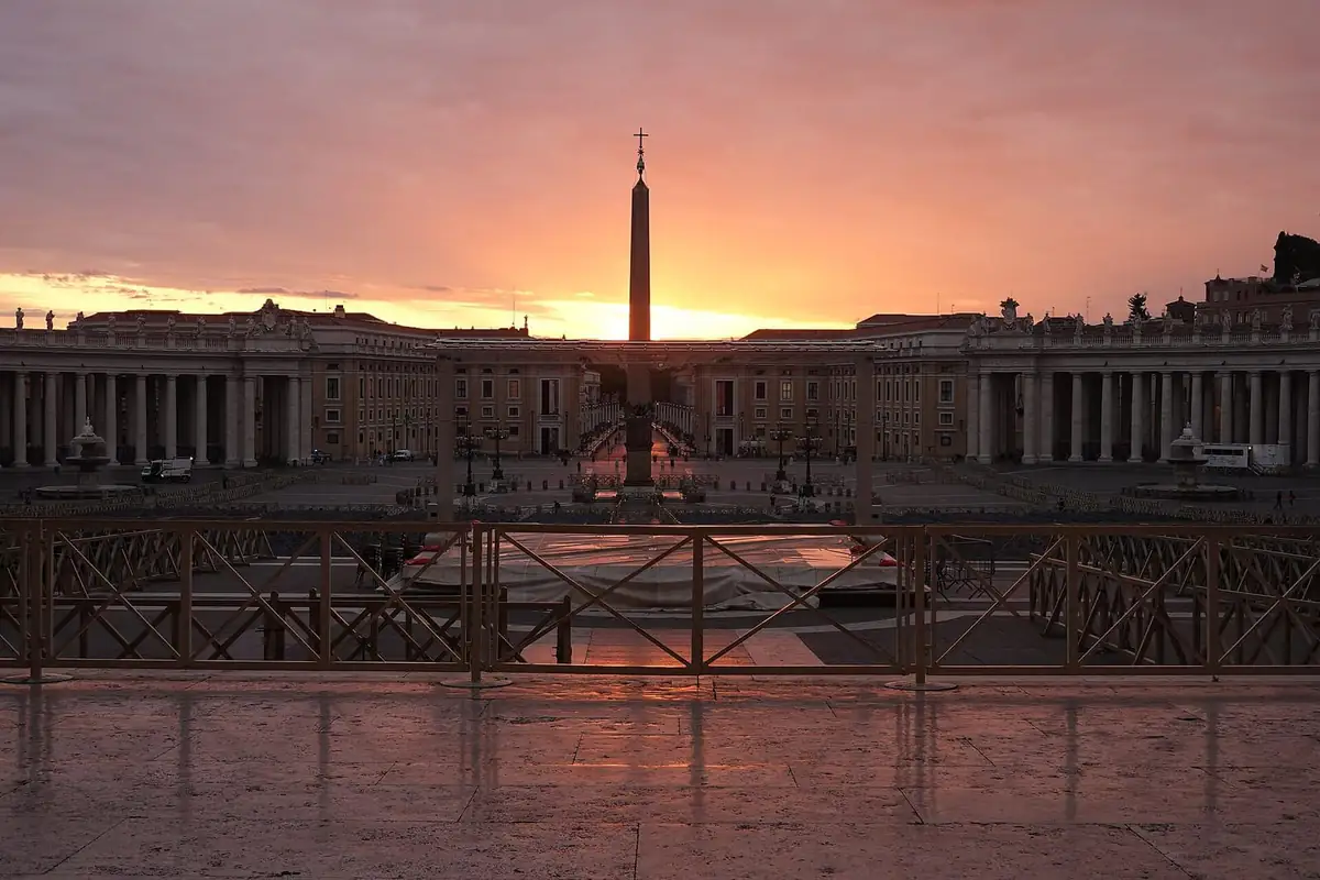 St Peter's Square in the Vatican at sunrise, with the obelisk silhouetted against the sky