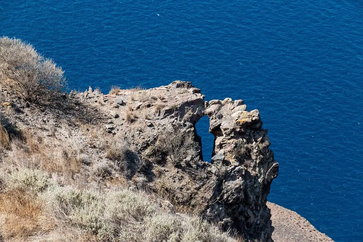 Rock arch on the caldera cliffs above the Aegean near Fira