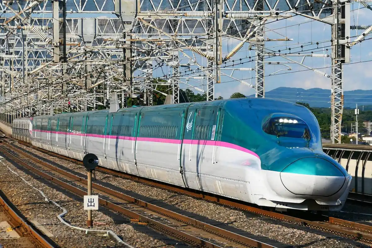 An E5 Hayabusa Shinkansen running under overhead wires