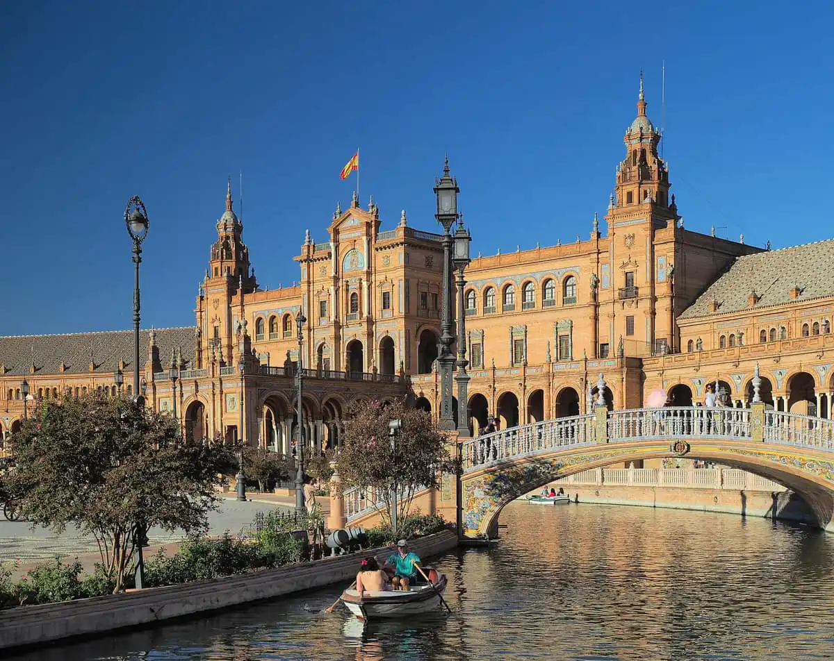 Tiled bridge and canal with a rowboat at Plaza de Espana in Seville