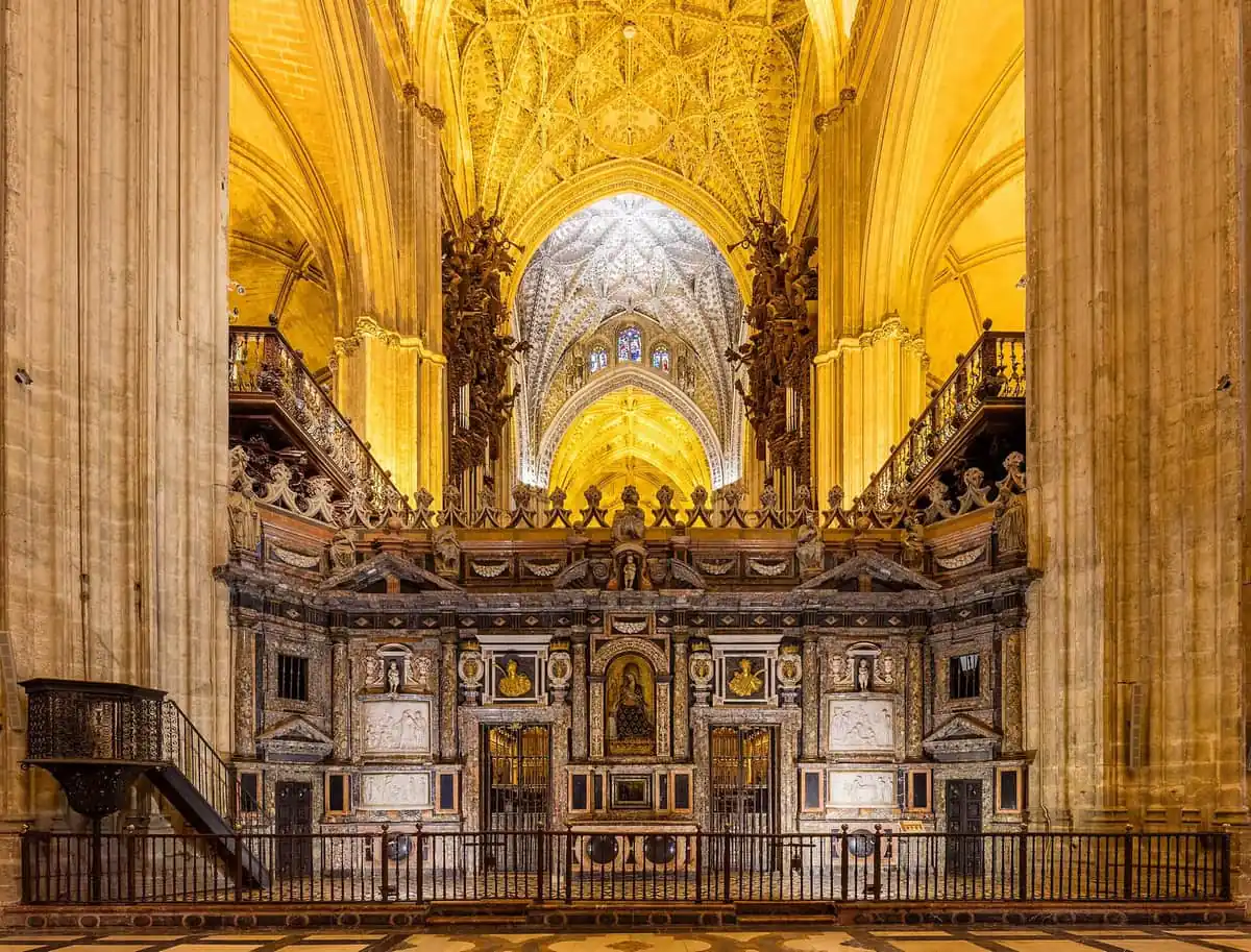 The carved marble Trascoro choir screen inside Seville Cathedral beneath a gilded vaulted ceiling