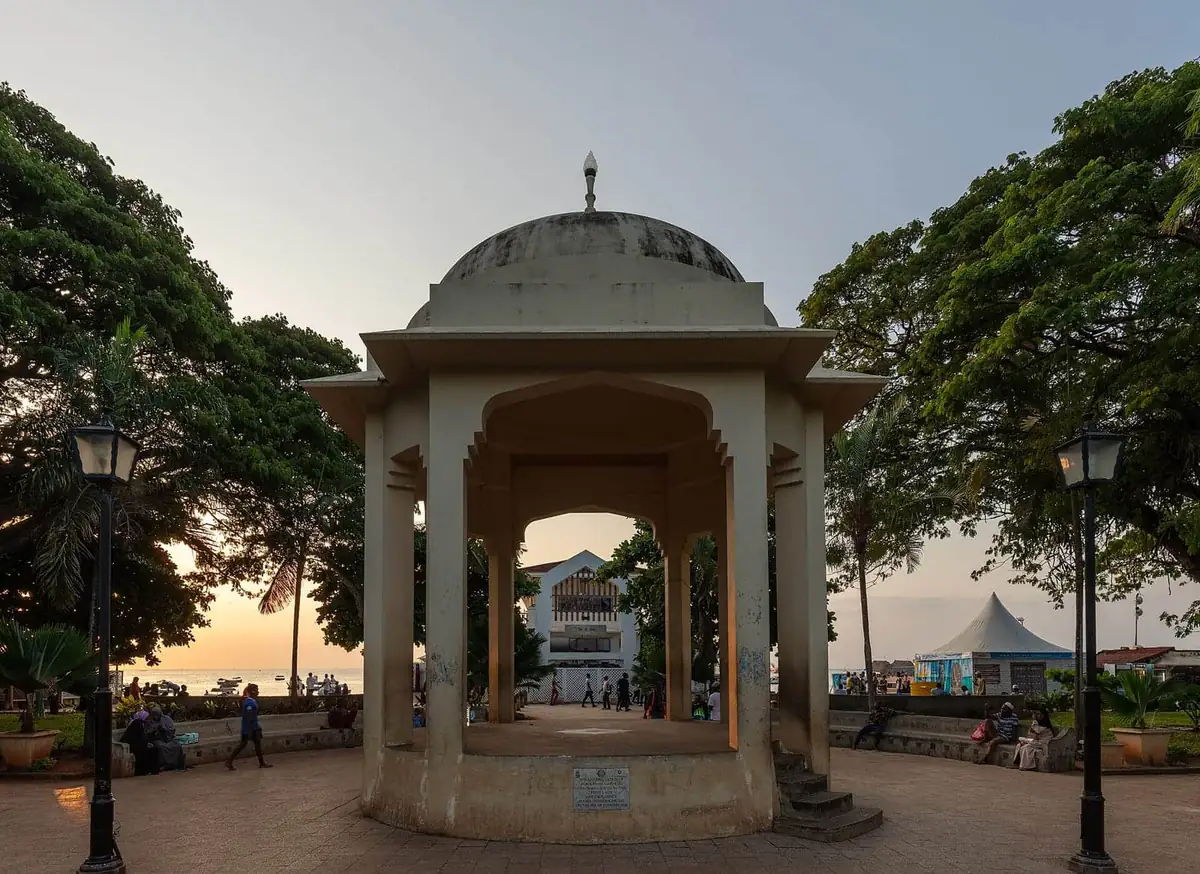 The domed bandstand in Forodhani Gardens at sunset, with the sea and evening crowds behind it