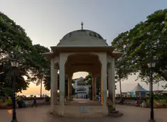 The domed bandstand in Forodhani Gardens at sunset, with the sea and evening crowds behind it