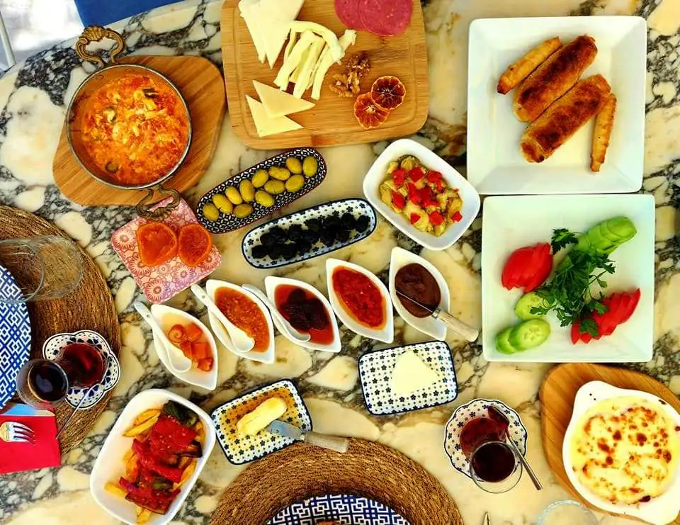 A full Turkish breakfast spread of cheeses, olives, jams, menemen and tea