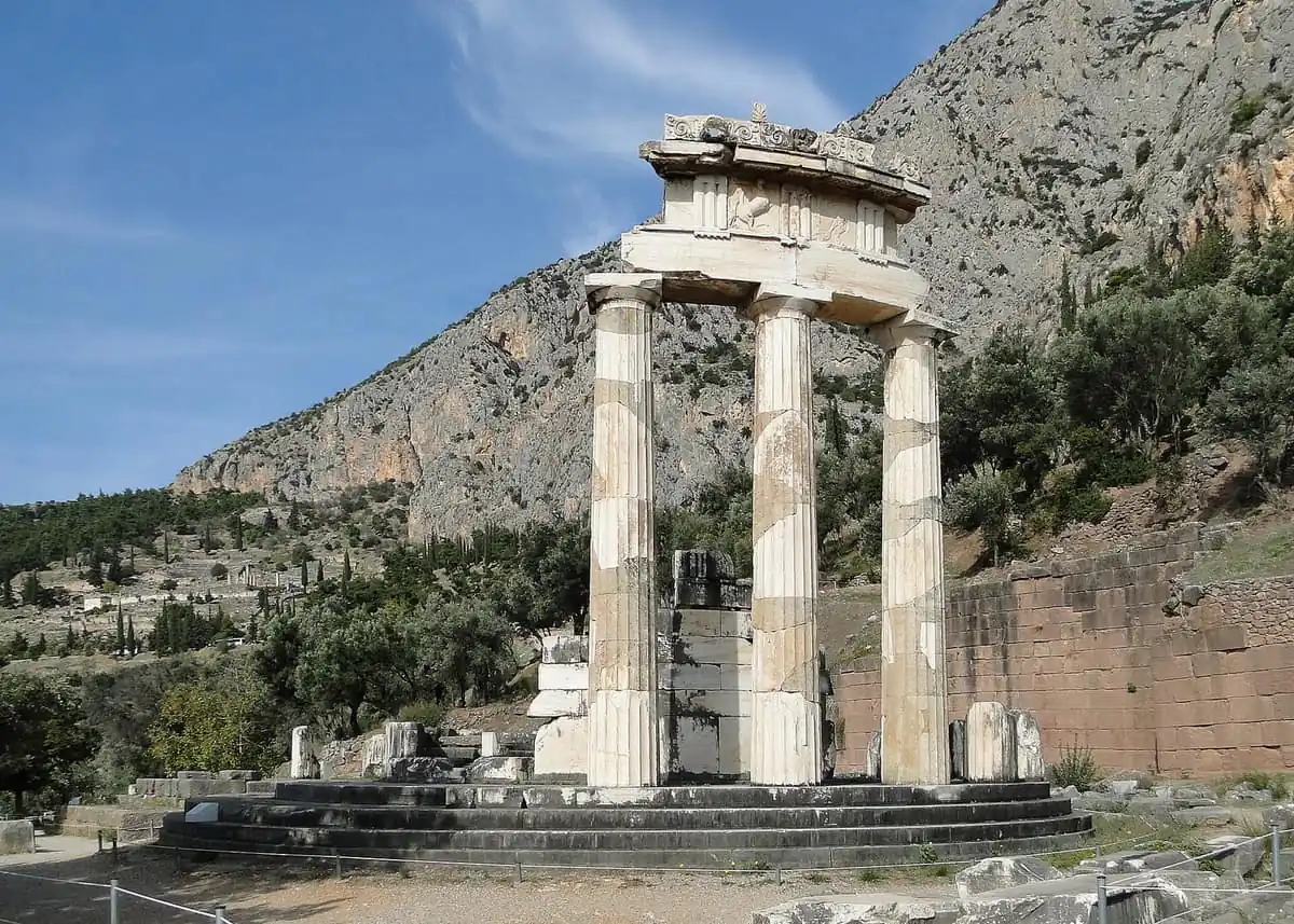 The three surviving columns of the Tholos at Delphi with a limestone mountainside behind