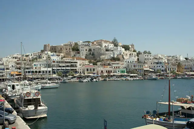 Whitewashed Naxos Town climbing the hill above the harbour, with fishing boats in the foreground