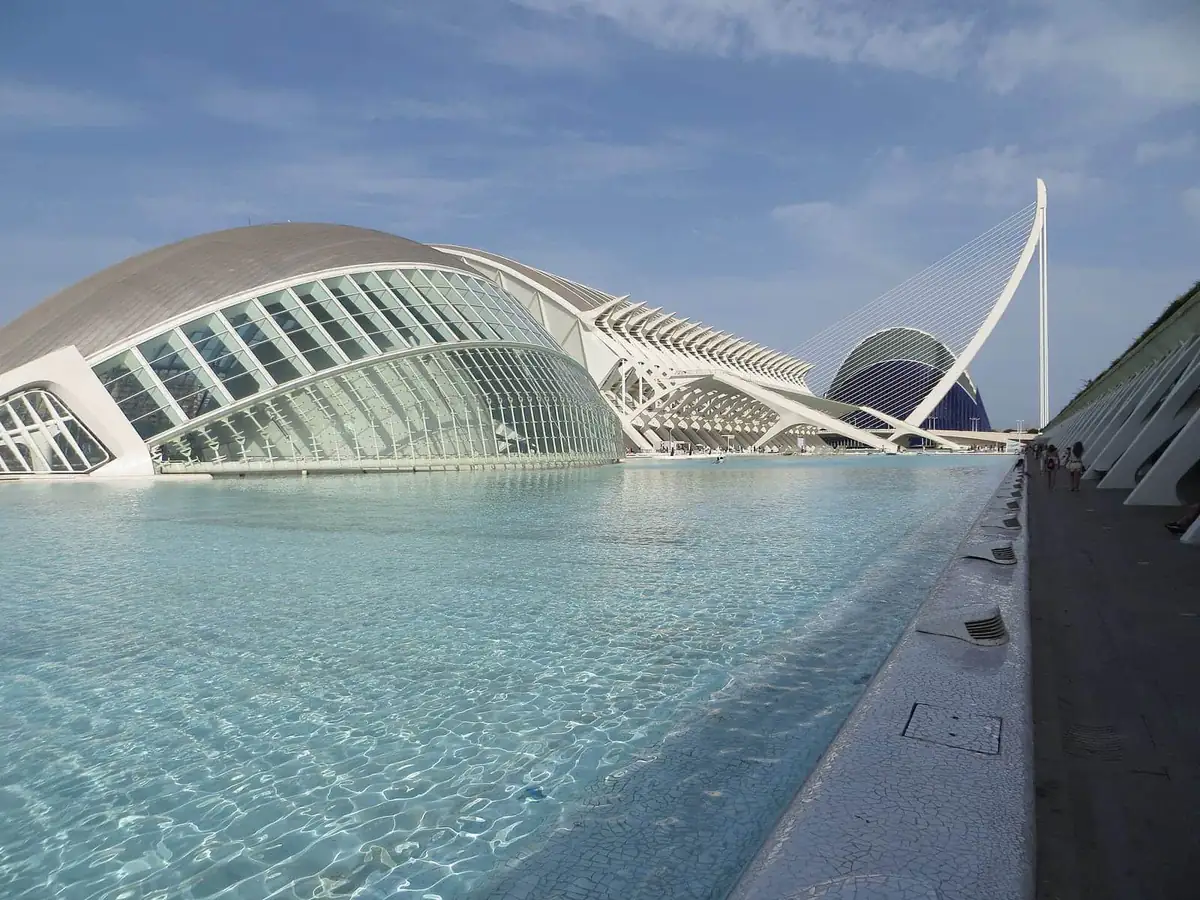 The white curved buildings of Valencia's City of Arts and Sciences reflected in their shallow pools on a clear day