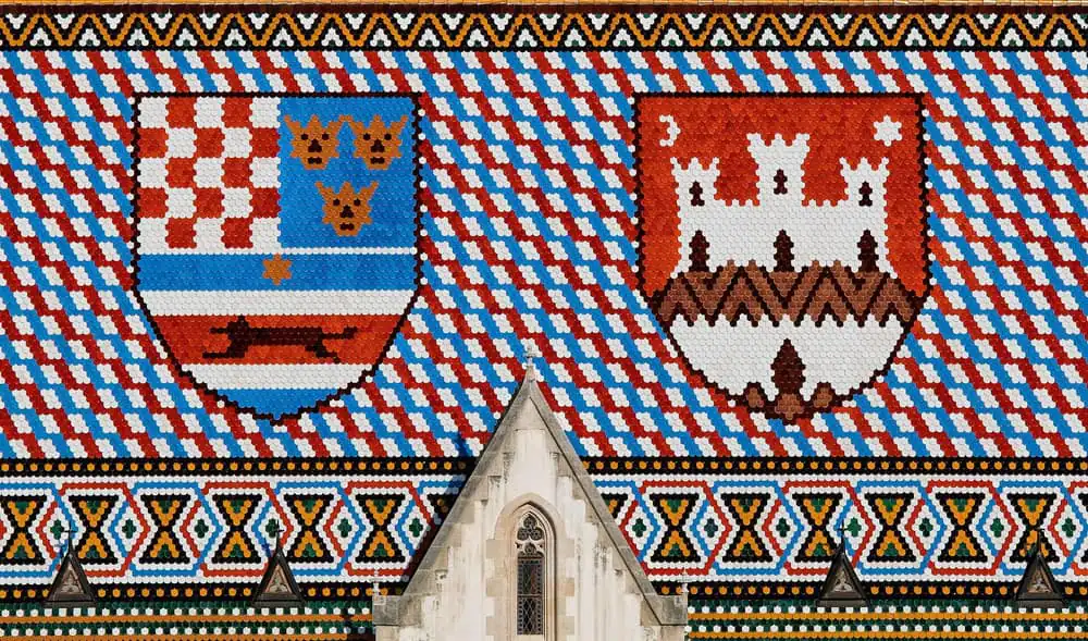 Close view of the tiled roof of St Mark's Church with its coat of arms panels